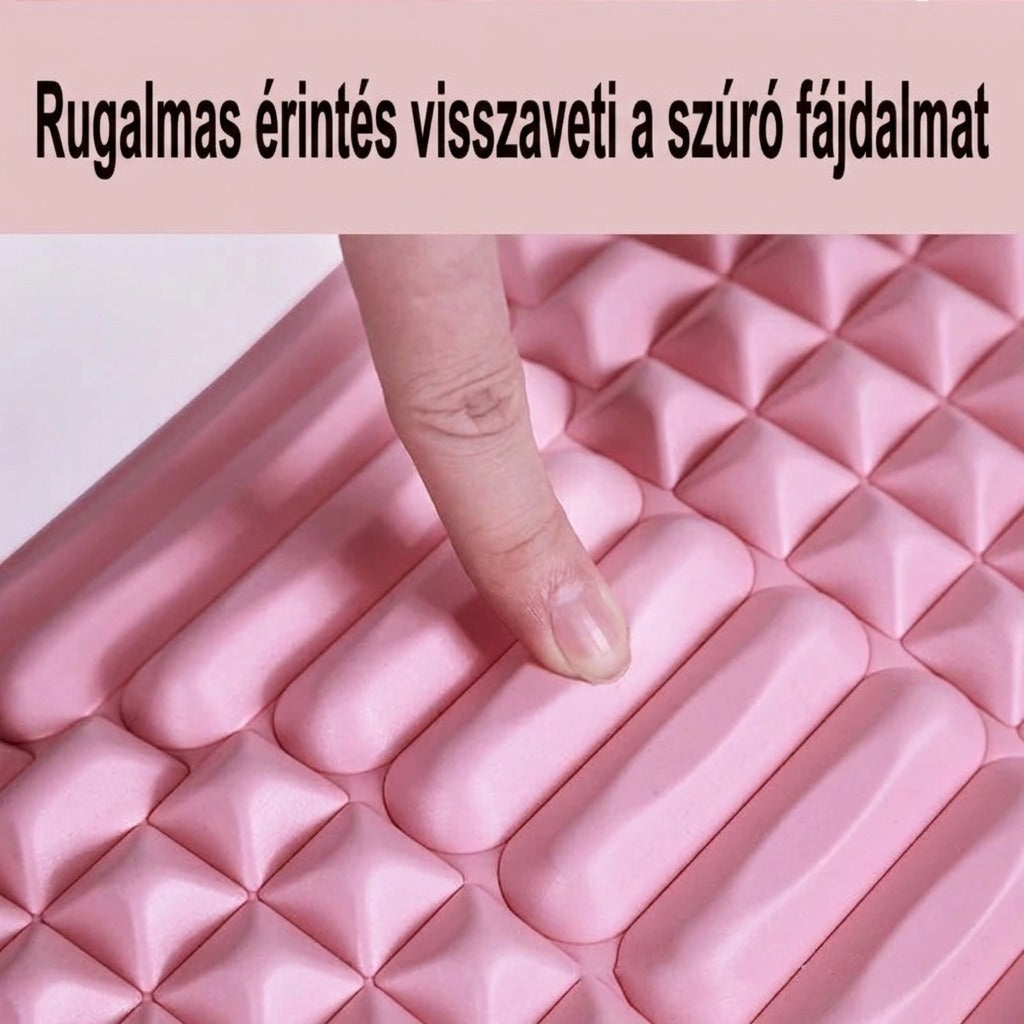 Rugalmas rózsaszín masszázsbetét, amelyet egy ujj nyom befelé.