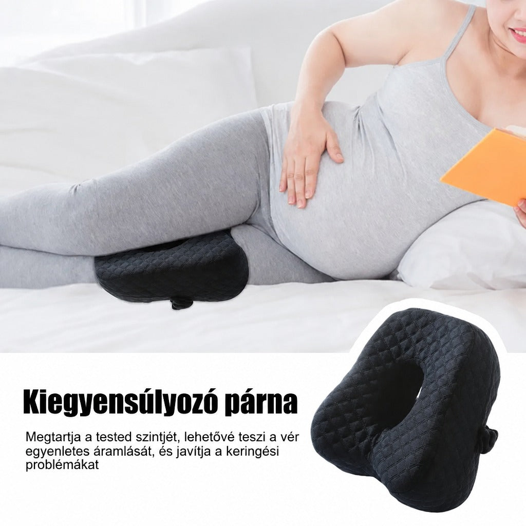 Fekvő terhes nő lábai között fekete anatómiai kiegyensúlyozó párnával.