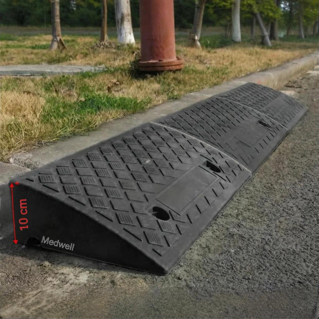 Fekete gumiból készült, bordázott felületű 10 cm magas járdaszegély rámpa az út szélén.
