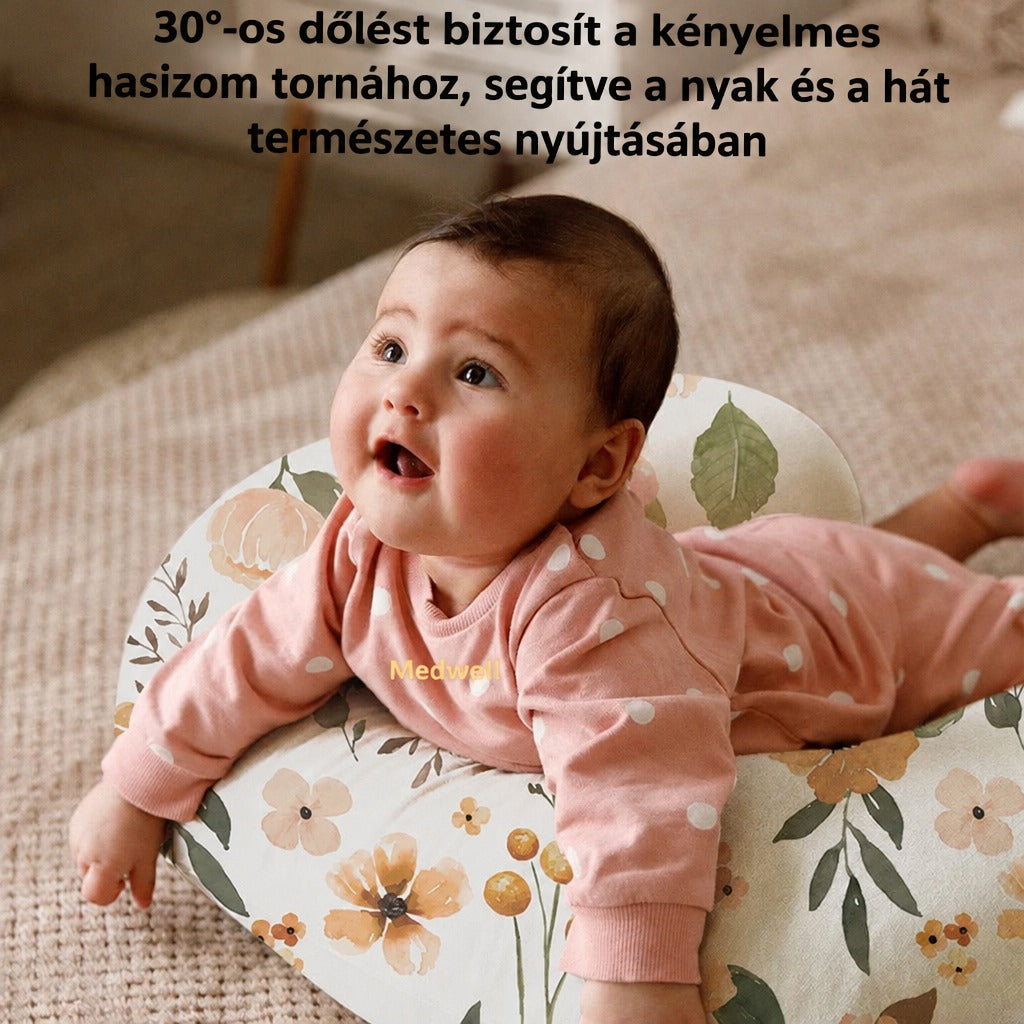 Babapárnán hason fekvő, mosolygó kisbaba.